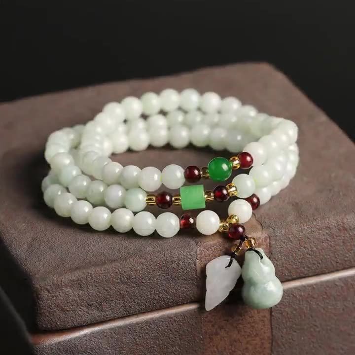 Buddha jewelry:This natural jadeite three-wrap bracelet is a charming blend of elegance and symbolism. Adorned with delicate accent beads, vibrant garnet, a meaningful gourd, and two Pixiu pendants, it carries both aesthetic appeal and cultural significance. Designed to fit comfortably, it is suitable for wrist circumferences ranging from 14 to 16cm, making it a versatile accessory for various wrist sizes. Whether worn as a personal talisman or a stylish addition to an outfit, this bracelet effortlessly combines natural beauty with thoughtful details.